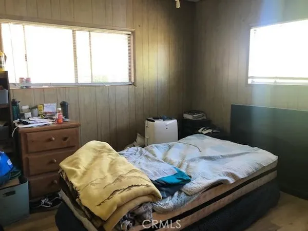 a bedroom with a bed and windows