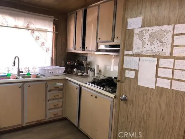 a kitchen with stainless steel appliances a sink cabinets and a window