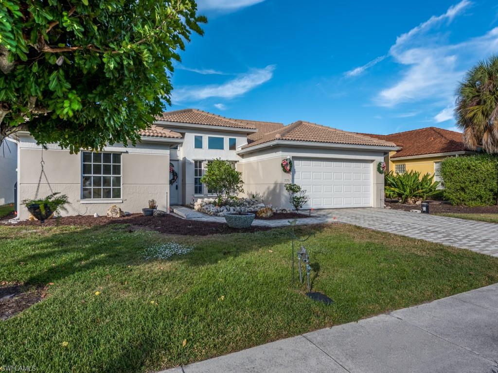 7175 Mill Pond Circle Naples, FL 34109 - Photo 2 of 14 a front view of a house with garden