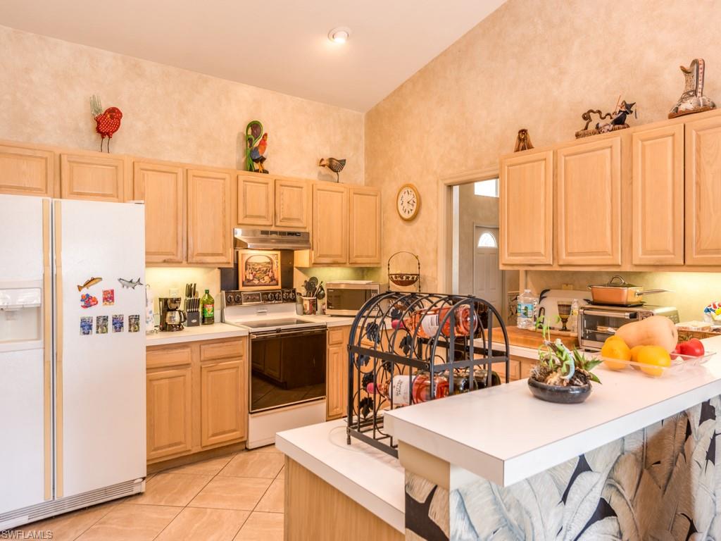 7175 Mill Pond Circle Naples, FL 34109 - Photo 6 of 14 a kitchen with stainless steel appliances kitchen island granite countertop a sink and cabinets