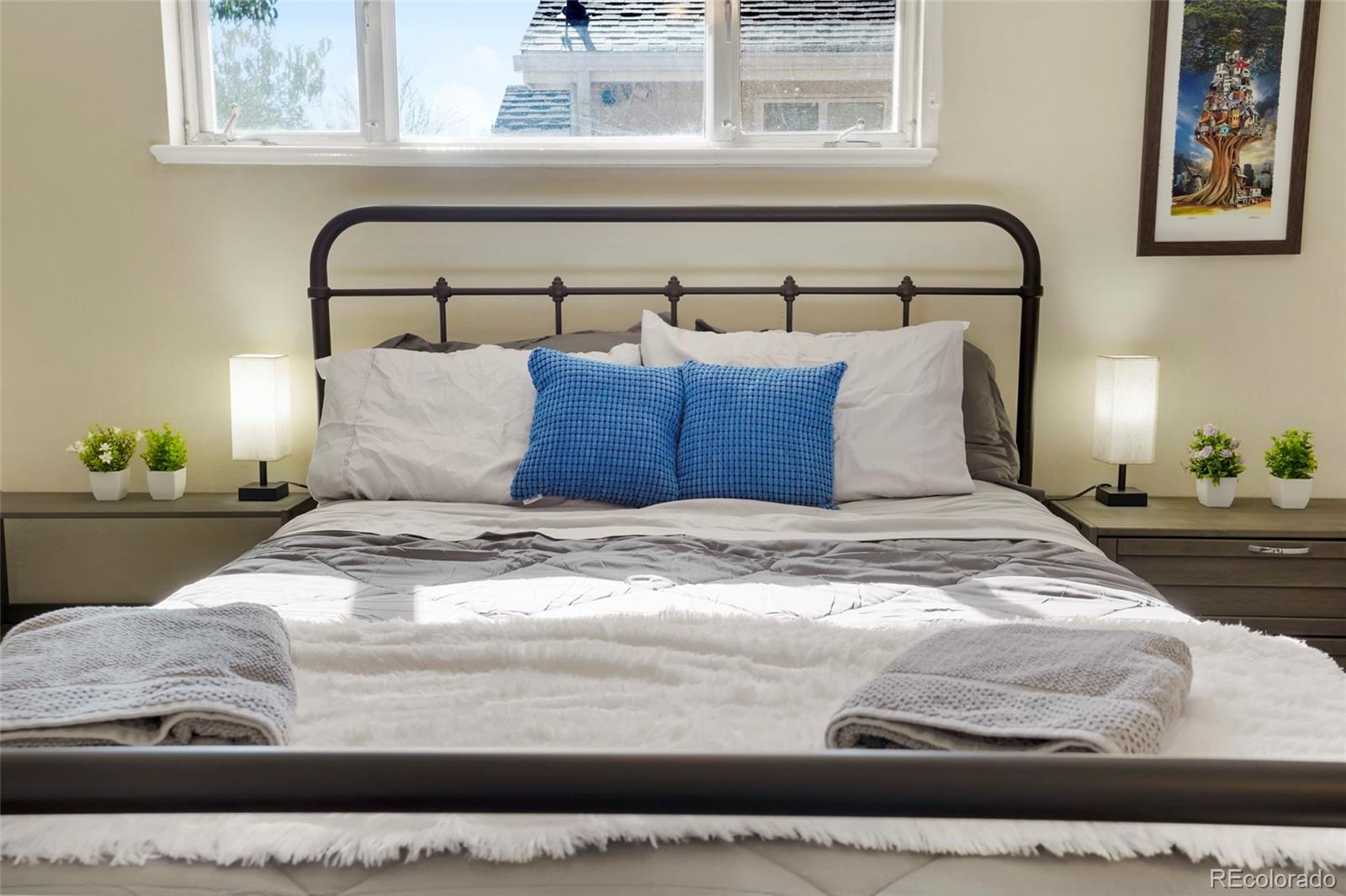 1070 South Decatur Street Denver, CO 80219 - Photo 16 of 18 a large bed sitting in a bedroom next to a window