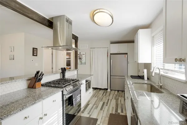 a kitchen with granite countertop a sink stove and refrigerator