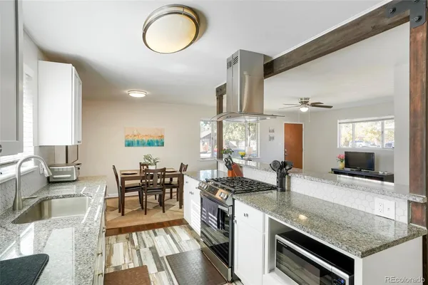 a kitchen with stainless steel appliances granite countertop a stove a sink and a dining table