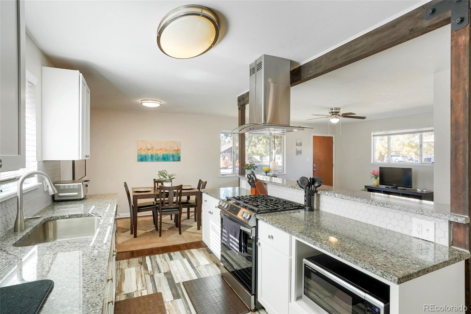 1070 South Decatur Street Denver, CO 80219 - Photo 6 of 18 a kitchen with stainless steel appliances granite countertop a stove a sink and a dining table