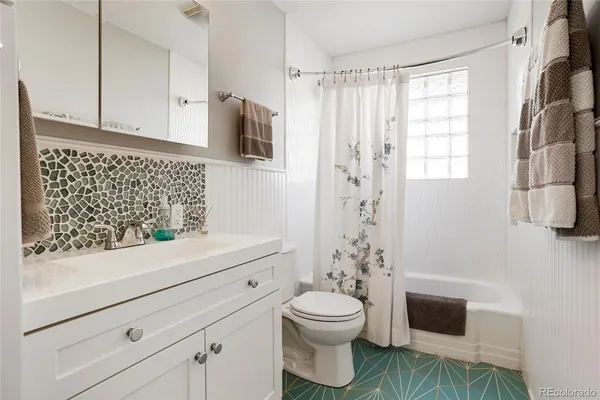 a bathroom with a sink a toilet and shower curtain