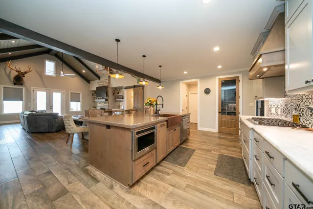 a large kitchen with stainless steel appliances kitchen island granite countertop a sink and cabinets