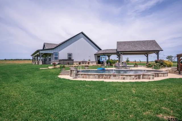 a view of a house with backyard sitting area and garden