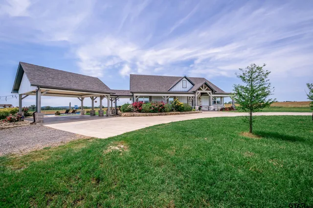 a view of house with yard and outdoor seating