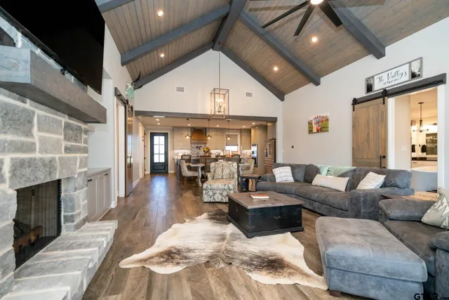 a dining room with stainless steel appliances kitchen island granite countertop a table chairs and a refrigerator