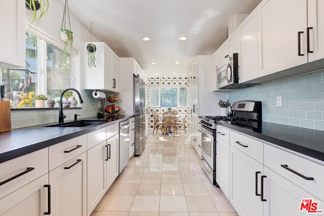 3838 Crestview Road Culver City, CA 90232 - Photo 16 of 53 a kitchen with stainless steel appliances a sink dishwasher stove refrigerator and cabinets