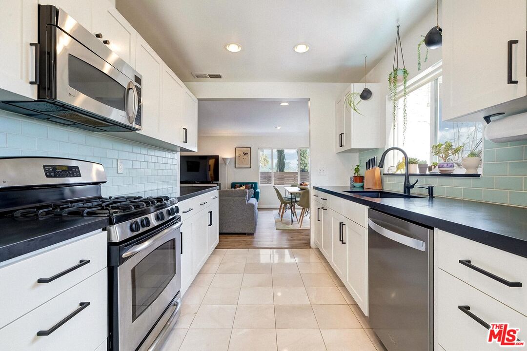 3838 Crestview Road Culver City, CA 90232 - Photo 19 of 53 a large kitchen with stainless steel appliances granite countertop a stove a sink and a microwave