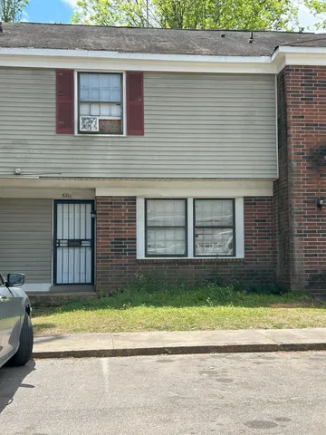 a view of a brick house with a yard