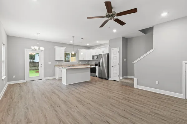 a view of kitchen with granite countertop cabinets and refrigerator