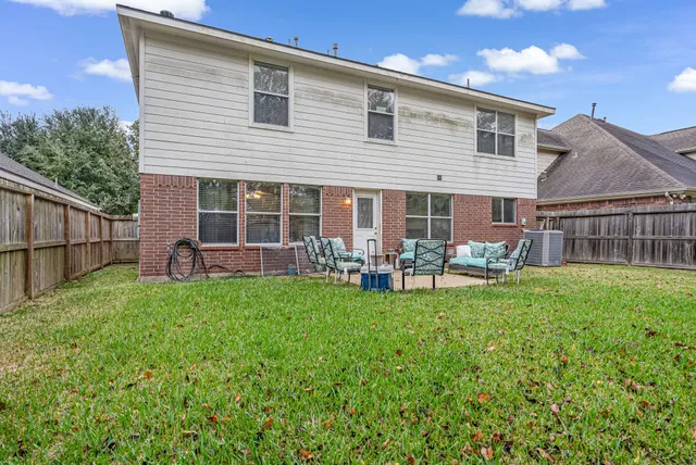 a view of a house with backyard and sitting area