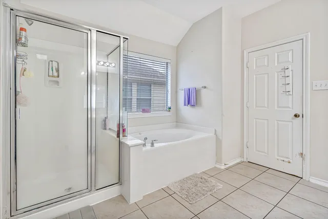 a bathroom with a tub shower and sink