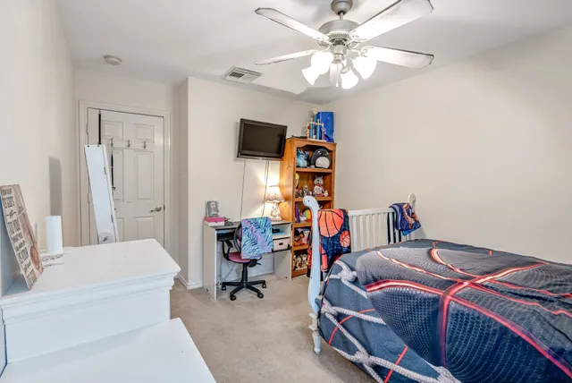 a bedroom with a bed a couch and a chandelier