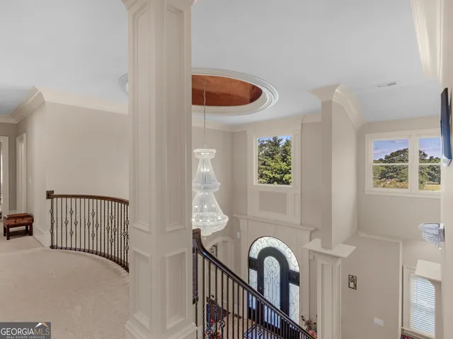 a view of a hallway with wooden floor and a potted plant