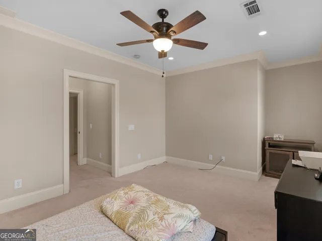 a bedroom with a bed and dresser with wooden floor
