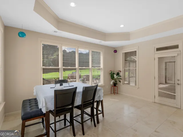a view of a patio with couches plants and large trees