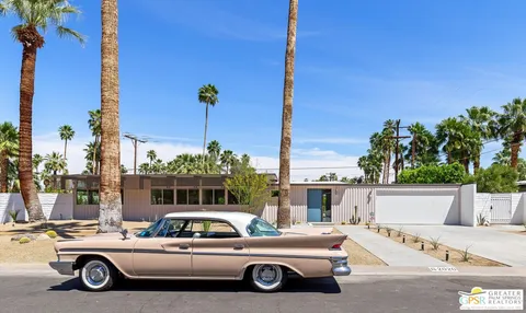 a front view of a building with cars parked