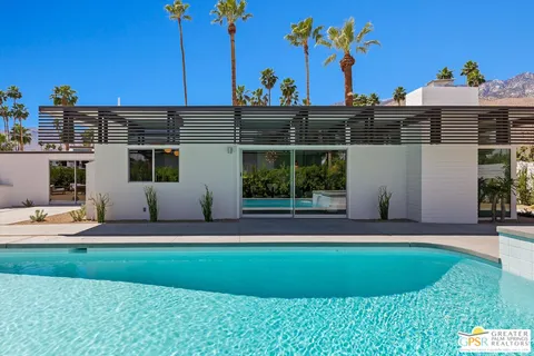 a view of swimming pool with outdoor seating and plants