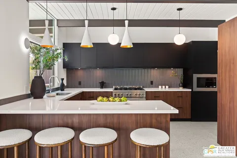 a kitchen with stainless steel appliances a refrigerator a sink a stove and white cabinets