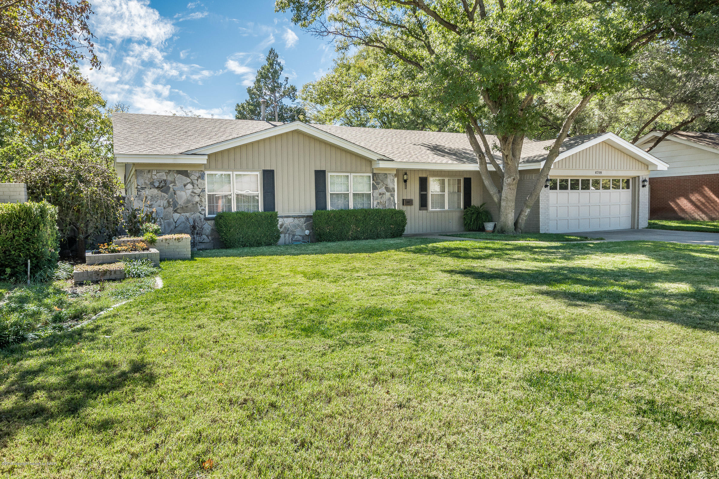 6709 Jameson Road Amarillo, TX 79106 - Photo 1 of 23 a front view of a house with a yard and trees