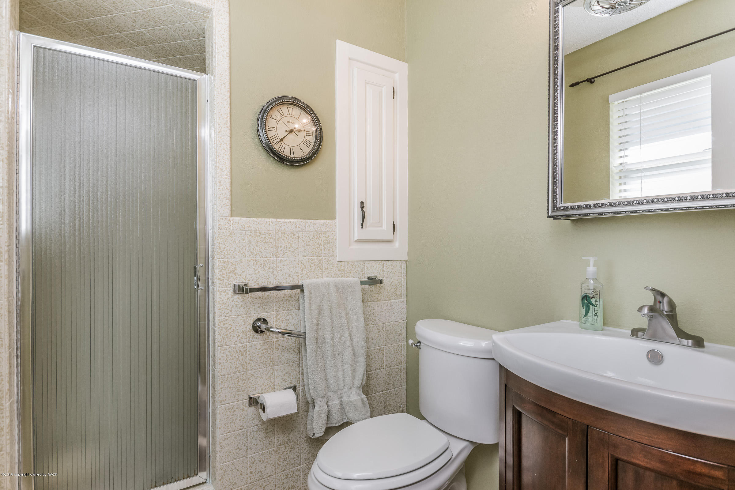 6709 Jameson Road Amarillo, TX 79106 - Photo 15 of 23 a bathroom with a toilet a sink and a mirror