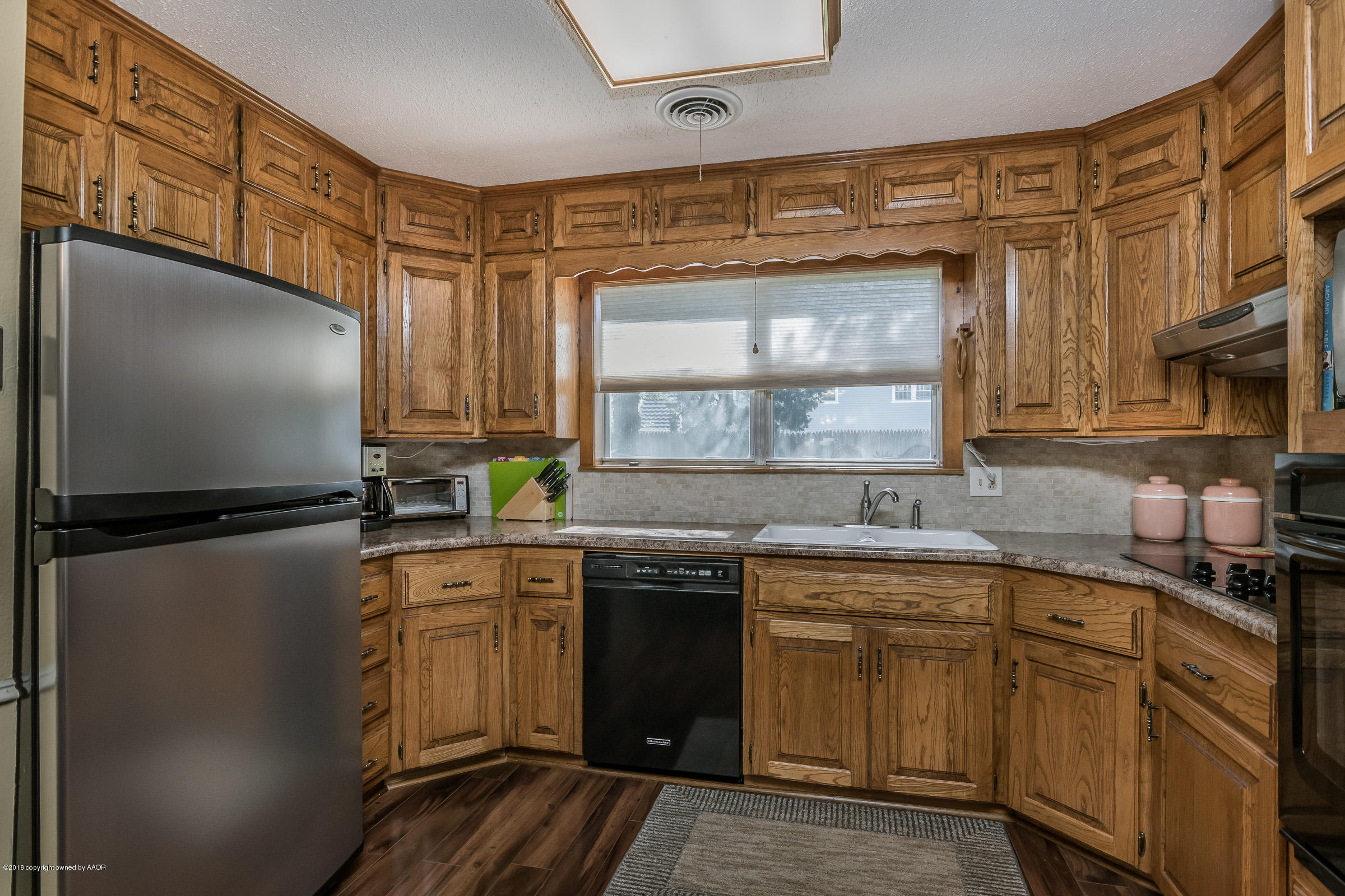 6709 Jameson Road Amarillo, TX 79106 - Photo 8 of 23 a kitchen with a sink a refrigerator and cabinets