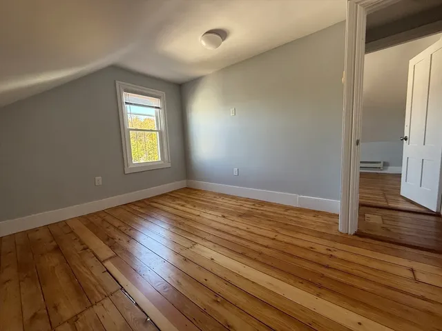 an empty room with wooden floor and a window