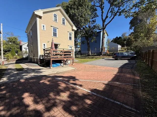 a view of a building with cars parked on the road