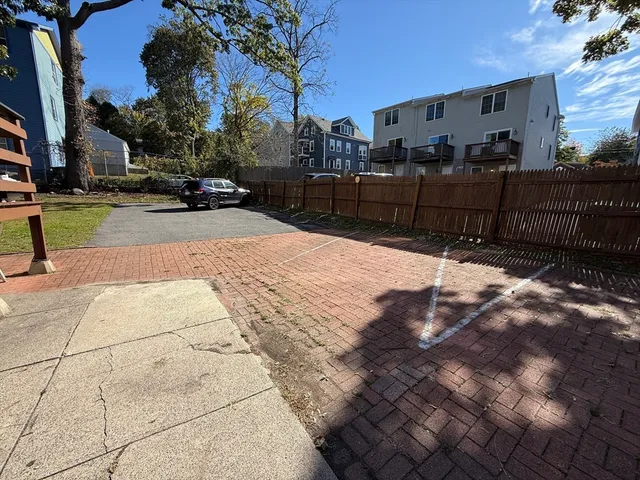 a view of a yard with cars on the road
