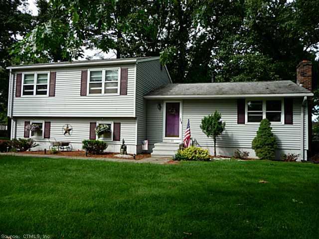 a front view of a house with a yard and trees