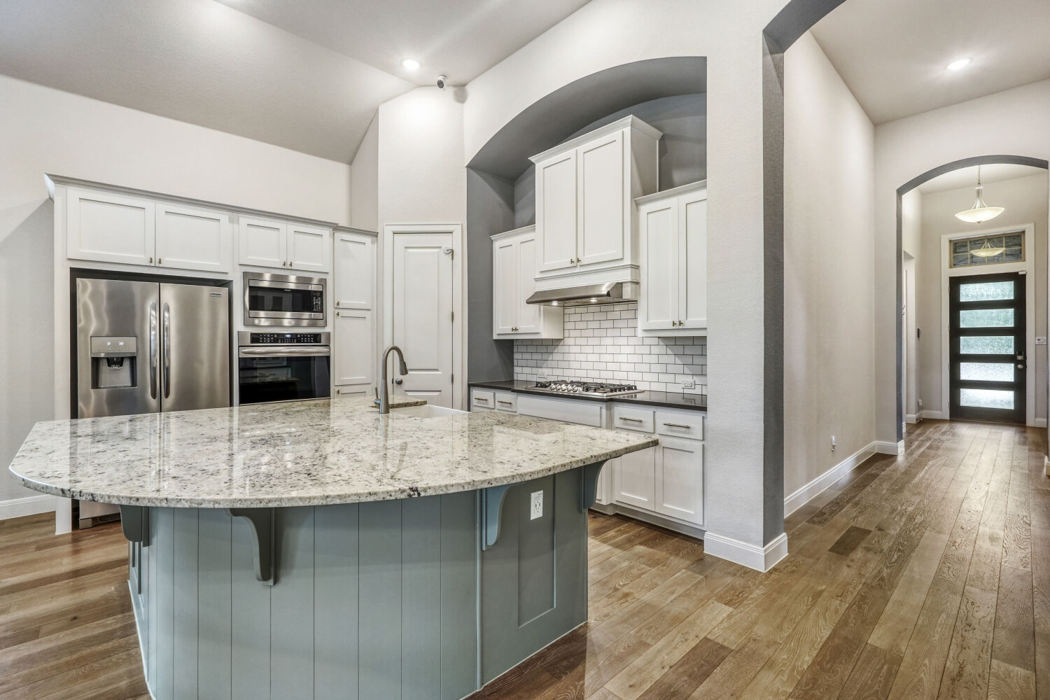 1401 Calago Cove Leander, TX 78641 - Photo 12 of 40 a kitchen with stainless steel appliances granite countertop a kitchen island and a refrigerator