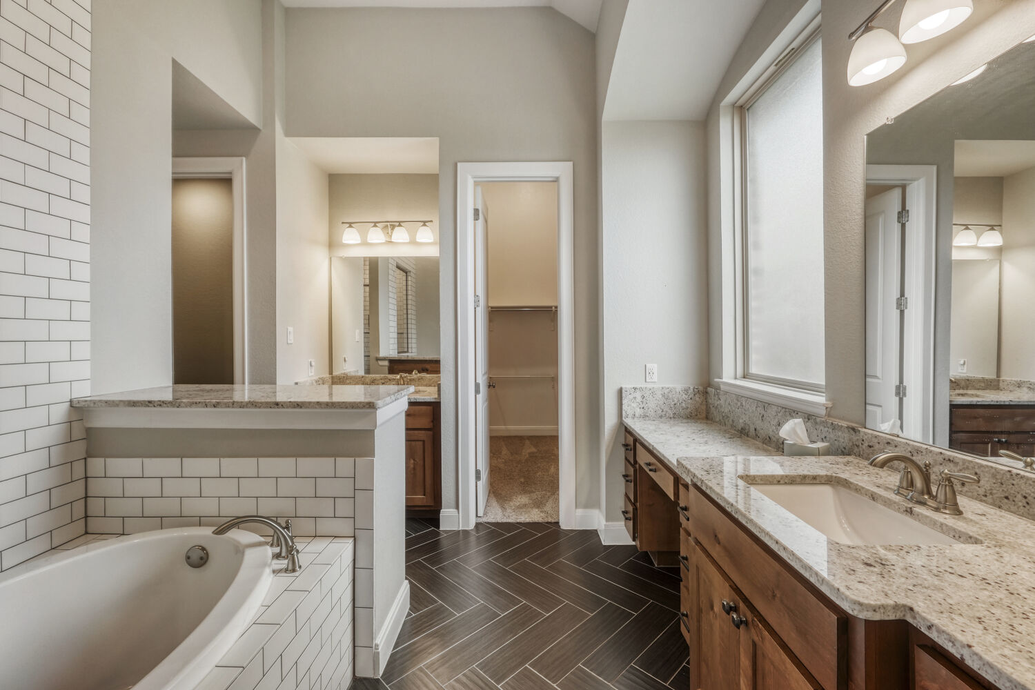 1401 Calago Cove Leander, TX 78641 - Photo 16 of 40 a spacious bathroom with a granite countertop tub sink and mirror