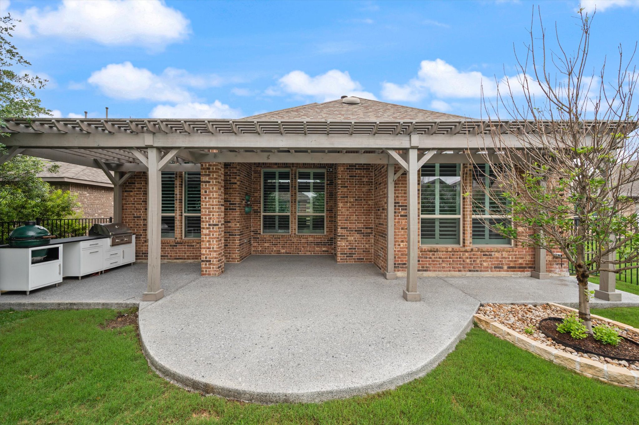 1401 Calago Cove Leander, TX 78641 - Photo 26 of 40 Expansive covered patio featuring a wood pergola, integrated outdoor kitchen with white cabinetry, and a built-in grill