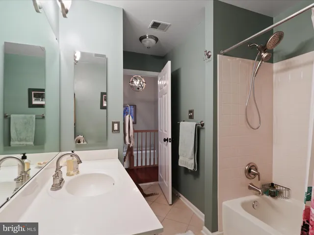 a bathroom with a tub sink and mirror