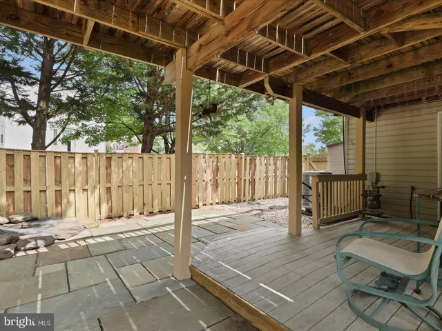 a view of a backyard with wooden floor and iron fence