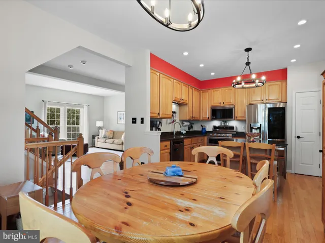 a kitchen with stainless steel appliances granite countertop a stove a kitchen island a large white cabinets and chairs