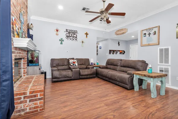 a living room with furniture a fireplace and wooden floor