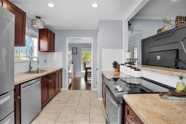a kitchen with stainless steel appliances granite countertop a sink stove and refrigerator