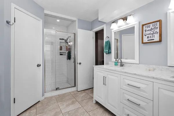 a spacious bathroom with a shower sink and mirror