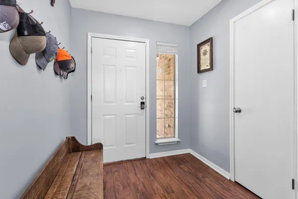 an entryway of a room with wooden floor and windows