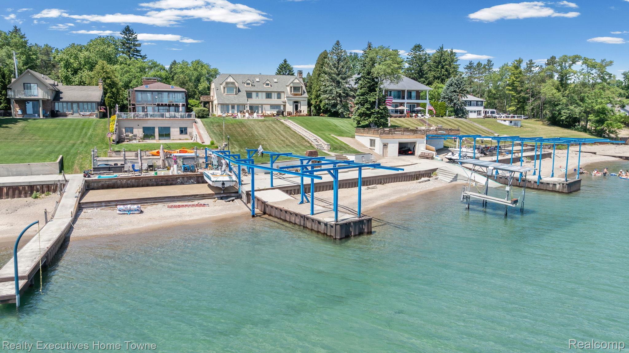 8308 Lakeshore Road Fort Gratiot, MI 48059 - Photo 18 of 79 Expansive waterfront property featuring a private sandy beach, multiple boat lifts, a concrete pier, and a substantial boat house