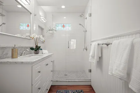 a bathroom with a granite countertop sink a shower and a mirror
