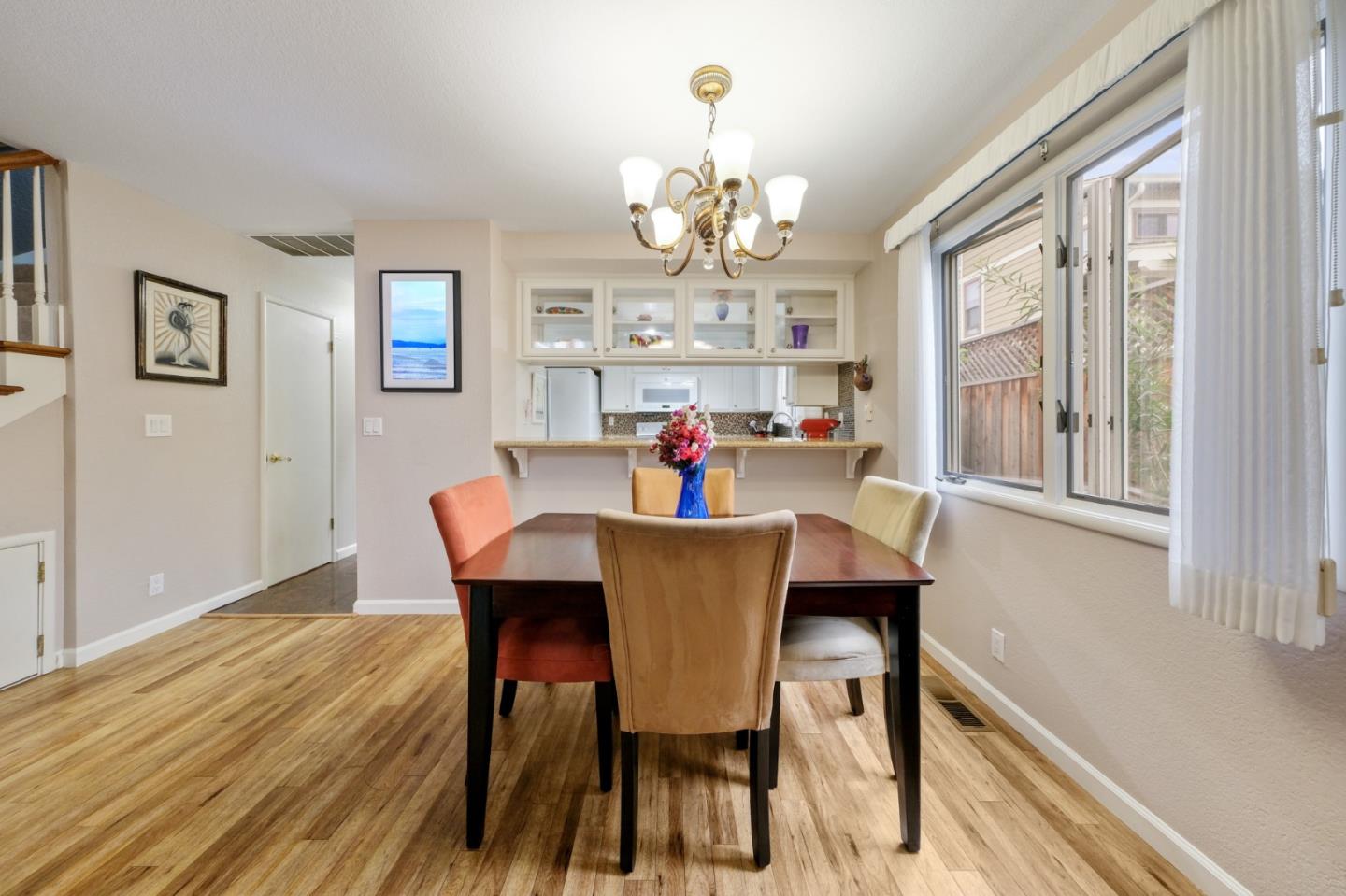 157 Redding Road Campbell, CA 95008 - Photo 10 of 31 a dining room with wooden floor a chandelier a wooden table and chairs
