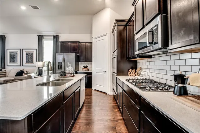 a kitchen with stainless steel appliances a sink stove and refrigerator