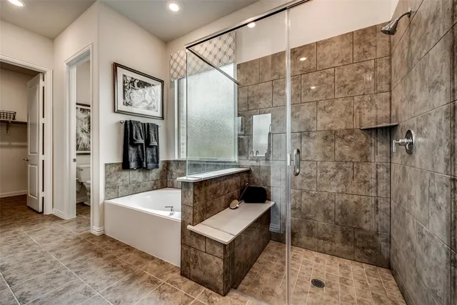 a bathroom with a tub a mirror and shower