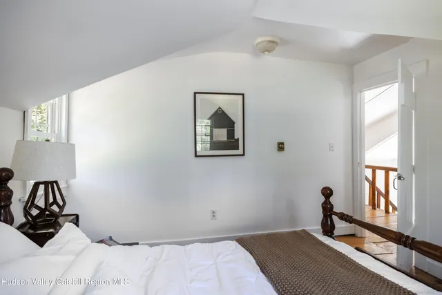 a bedroom with a bed and a large window