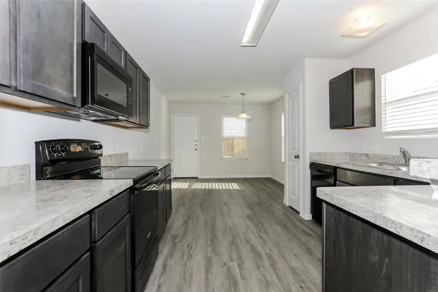 a kitchen with granite countertop stainless steel appliances and wooden cabinets